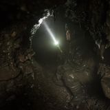 Mit einer Taschenlampe sucht Dima die Höhle nach Knochen ab. Die von den Jägern ausgespülten Löcher könnten jederzeit einstürzen.