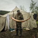 Stolz präsentiert Witja einen Mammutstoßzahn. Manche sind bis zu 25.000 Euro wert. Im Zelt dahinter leben zehn Männer.