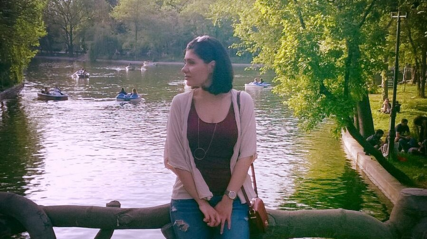 Frau sitzt auf Baumstamm vor See