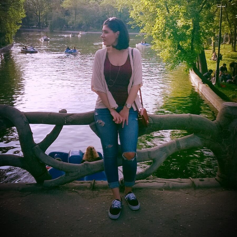 Frau sitzt auf Baumstamm vor See