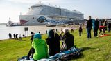 Viele Sehleute auf dem Deich: Sie beobachten, wie das Kreuzfahrtschiff "Aida Nova" während der Überführung auf der Ems von Schleppern durch das Ems-Sperrwerk Gandersum manövriert wird.