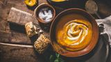 Ausgewogen essen  Gerade in den typischen Krankheitsmonaten ist es wichtig, seinen Körper mit allen wichtigen Vitaminen und Nährstoffen zu versorgen. So kann das Immunsystem ideal arbeiten und seiner Aufgabe nachgehen, Krankheitserreger zu bekämpfen. Neuere Forschung zeigt, dass auch die Gesamtheit aller Darmbakterien eine wichtige Rolle für das Immunsystem spielt - und die wollen gut ernährt sein.  Doch wie sieht eine gesunde Ernährung aus? Nach Angaben der Deutschen Gesellschaft für Ernährung (DGE) kommt es vor allem auf Vielfalt an. "Essen Sie abwechslungsreich", raten die Ernährungsexperten. "Wählen Sie überwiegend pflanzliche Lebensmittel." Mindestens drei Portionen Gemüse und zwei Portionen Obst am Tag sollten es sein. Darmbakterien lieben vor allem ballaststoffreiche Lebensmittel wie Kohl, Fenchel und Paprika oder Hülsenfrüchte wie Kichererbsen und Bohnen. Besonders wohltuend sind jetzt warme Gerichte mit saisonalem Gemüse - wie Kürbissuppe.