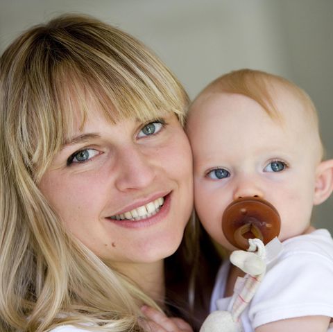 Eine junge Mutter mit Baby auf dem Arm