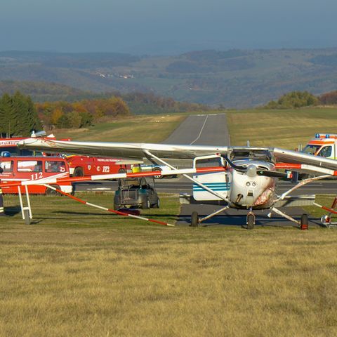 Feuerwehrleute stehen nach einem Flugunfall neben einem Sportflugzeug