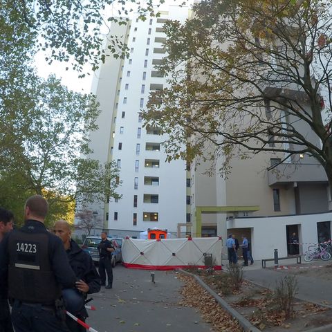 Polizisten vor einem Hochhaus in Berlin, an dem ein Junge von einem herabfliegenden Gegenstand erschlagen wurde