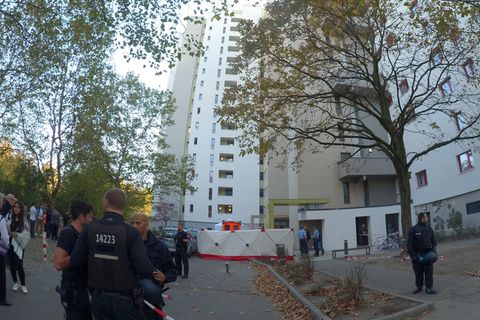 Polizisten vor einem Hochhaus in Berlin, an dem ein Junge von einem herabfliegenden Gegenstand erschlagen wurde