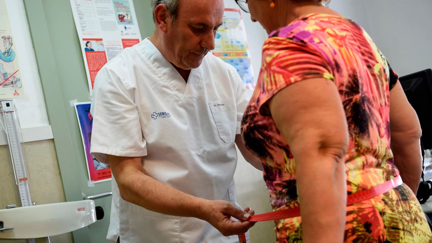 Doktor misst Bauchumfang einer Frau