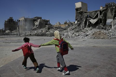 Alltag in Raqqa: Zwei Schülerinnen eilen an den Ruinen ihrer Stadt vorüber