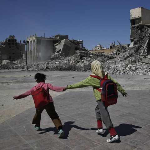 Alltag in Raqqa: Zwei Schülerinnen eilen an den Ruinen ihrer Stadt vorüber