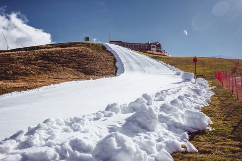 Die künstliche Schneise durch die grüne Berglandschaft: Skipisten-Präparierung am Resterkogel in den Kitzbüheler Alpen.