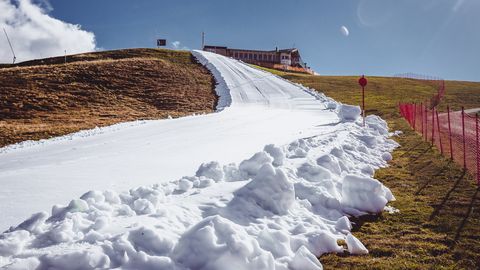 Die künstliche Schneise durch die grüne Berglandschaft: Skipisten-Präparierung am Resterkogel in den Kitzbüheler Alpen.