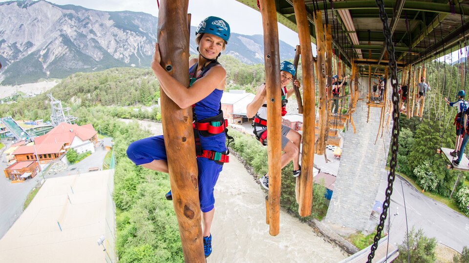 Ötztal, Österreich Menschen klettern im Hochseilgarten über einen Fluss