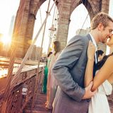 Brautpaar küsst sich auf Brücke