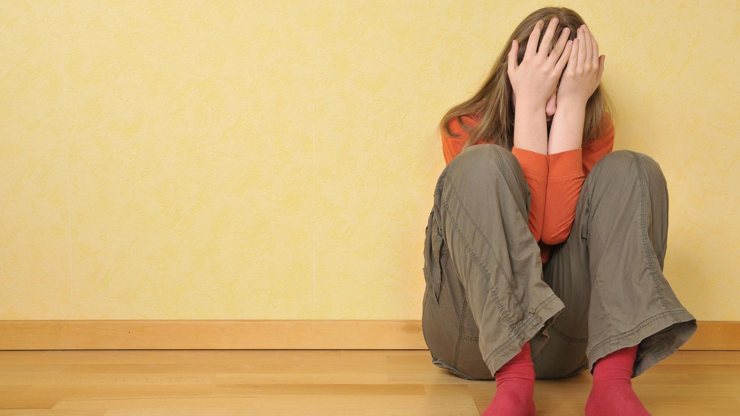 Eine schockierte 14-Jährige kauert am Boden