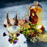 Walpurgisnacht      Der Cocktail: 1,1 l Cocchi Americano, 675 ml Perry's Tot Navy Strength Gin, 450 ml Brennivin Aquavit, 450 ml Chief Gowanus Gin, 450 ml Bio-Vollmilch, 225 ml Strega, 2 EL Zitronensäurelösung, 15 ml Regan's Orange Bitters, 2 große lebensmittelechte Behälter aus Plastik, Seihtuch, Kelle Spitzsieb      Perry's Tot Navy Strength Gin, Strega, Brennivin, Zitronensäurelösung und den Bitter in einen großen Behälter geben und verrühren. Milch in das zweite große Gefäß geben und langsam die Alkoholmischung hineingießen. (Es ist für den Gerinnungsprozess wichtig, dass der Alkohol in die Milch gegossen wird und nicht umgekehrt.) Mit Frischhaltefolie abdecken und über Nacht im Kühlschrank stehen lassen. Am nächsten Tag ein Seihtuch in ein großes Spitzsieb legen und die Mischung vorsichtig mit der Kelle hineingießen, sodass die Feststoffe der Milch nicht aufgerührt werden. (Um den Drink klar zu bekommen, muss die Mischung mehrmals durch ein feines Seihtuch gefiltert werden.) Cocchi Americano dazugeben und umrühren. Die Mischung in sterilisierte Flaschen füllen. Hält sich gekühlt jahrelang.