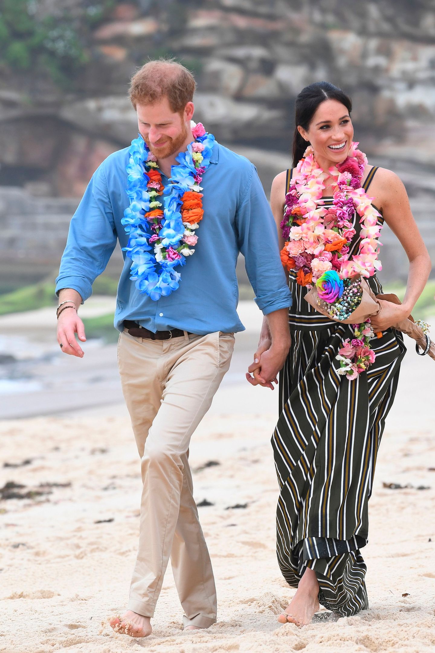 Hand und Hand und ohne Schuhe spazierten Prinz Harry und seine Frau Meghan am Strand entlang. Wären da nicht tausende Schaulustige, man könnte die beiden für ganz normale Urlauber halten.