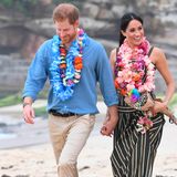 Hand und Hand und ohne Schuhe spazierten Prinz Harry und seine Frau Meghan am Strand entlang. Wären da nicht tausende Schaulustige, man könnte die beiden für ganz normale Urlauber halten.