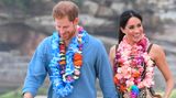 Hand und Hand und ohne Schuhe spazierten Prinz Harry und seine Frau Meghan am Strand entlang. Wären da nicht tausende Schaulustige, man könnte die beiden für ganz normale Urlauber halten.