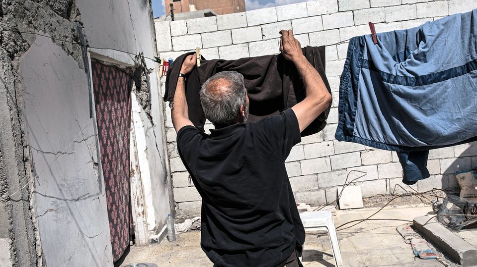 Ahmad Abdullah hängt im Hof seines zerstörten Hauses Wäsche auf