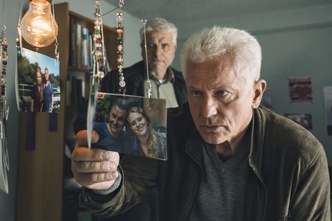 Kriminalhauptkommissar Franz Leitmayr (Udo Wachtveitl) und sein Kollege Ivo Batic (Miroslav Nemec) sichten in Melanies Zimmer Fotos von der Verschwundenen.