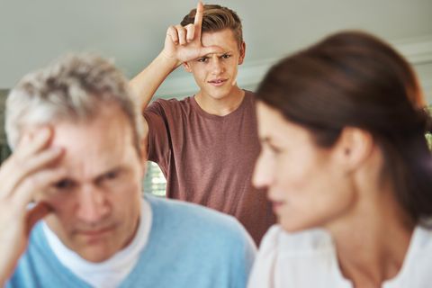 Ein Junge in der Pubertät formt Daumen und Zeigefinger zum Loser-L