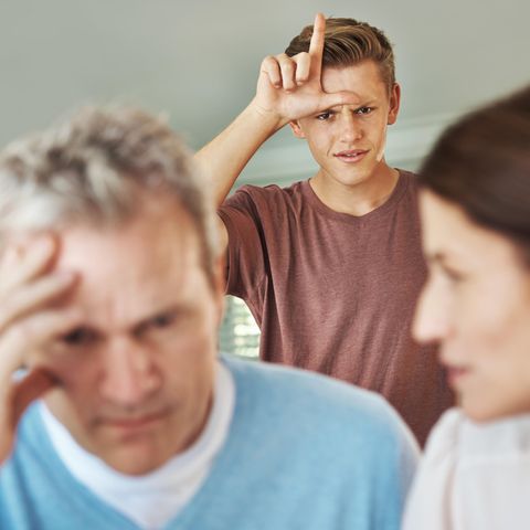 Ein Junge in der Pubertät formt Daumen und Zeigefinger zum Loser-L