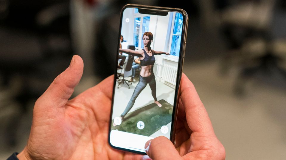 Der Apple-Chef probiert die Augmented-Reality-Funktion der Fitness-App aus