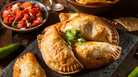 Bild 1 von 16 der Fotostrecke zum Klicken:  Empanadas sind Teigtaschen, gefüllt mit Schwein, Rind oder Pute, dazu Käse, Bohnenmus und auch gewürfelten Kartoffeln. Die Taschen werden in heißem Fett gebacken. Und gegessen werden sie meist ohne Besteck - sondern als "Snack to go".