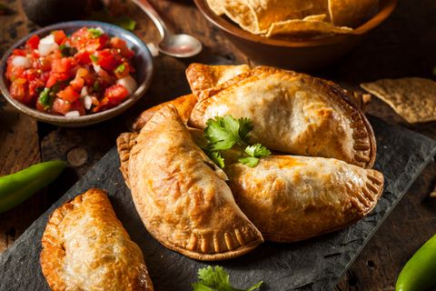 Bild 1 von 16 der Fotostrecke zum Klicken:  Empanadas sind Teigtaschen, gefüllt mit Schwein, Rind oder Pute, dazu Käse, Bohnenmus und auch gewürfelten Kartoffeln. Die Taschen werden in heißem Fett gebacken. Und gegessen werden sie meist ohne Besteck - sondern als "Snack to go".