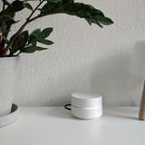 Google Wifi stebht auf einer weißen Fernsehbank