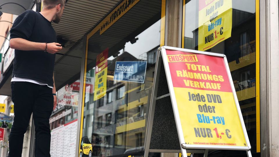 Ein Mann geht an einem Schaufenster einer Videothek vorbei
