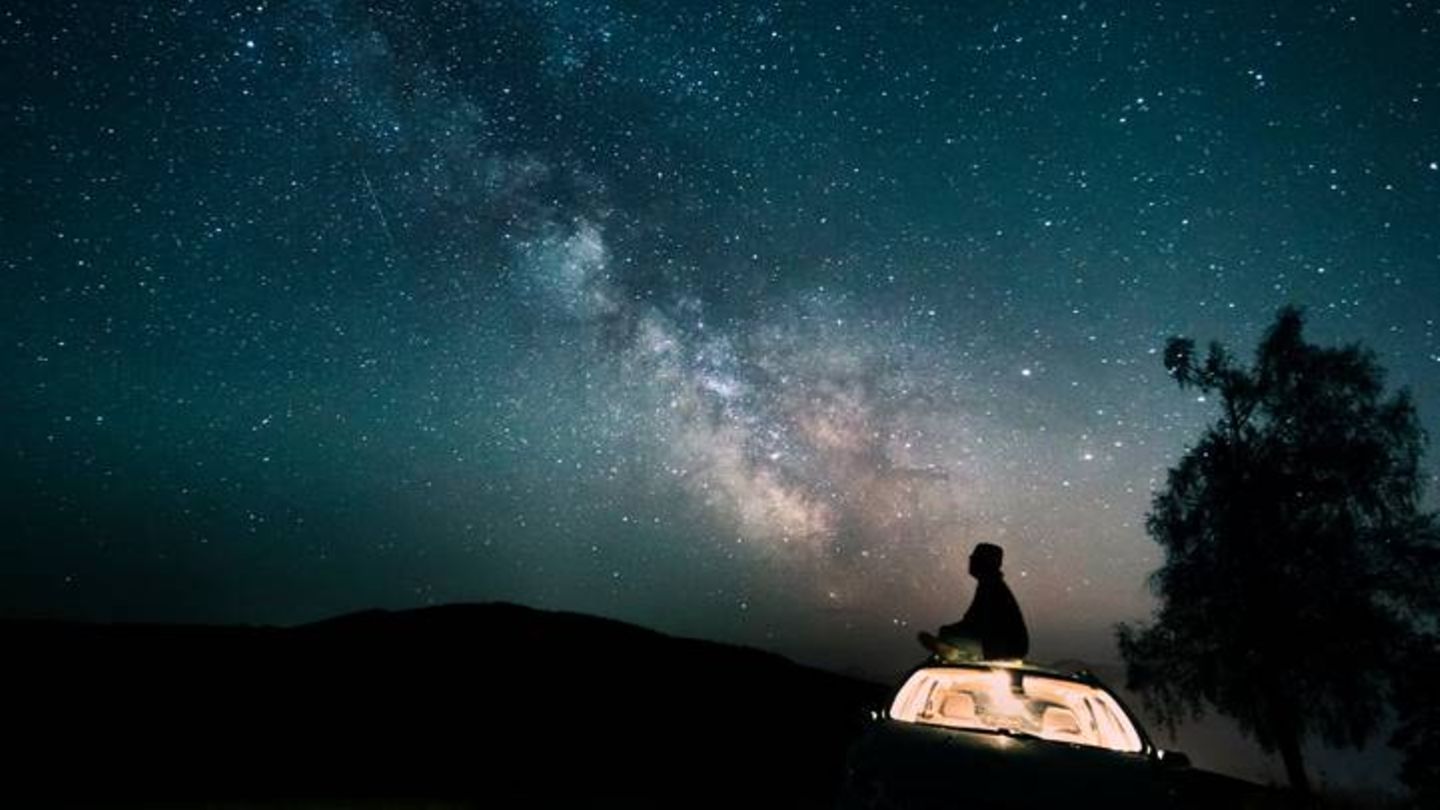Trennungsschmerz Mann sitzt und guckt in Sternenhimmel