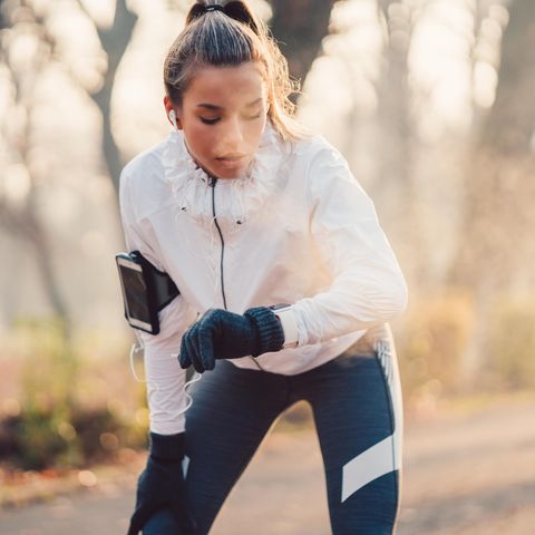Eine junge Frau joggt durch einen herbstlichen Wald