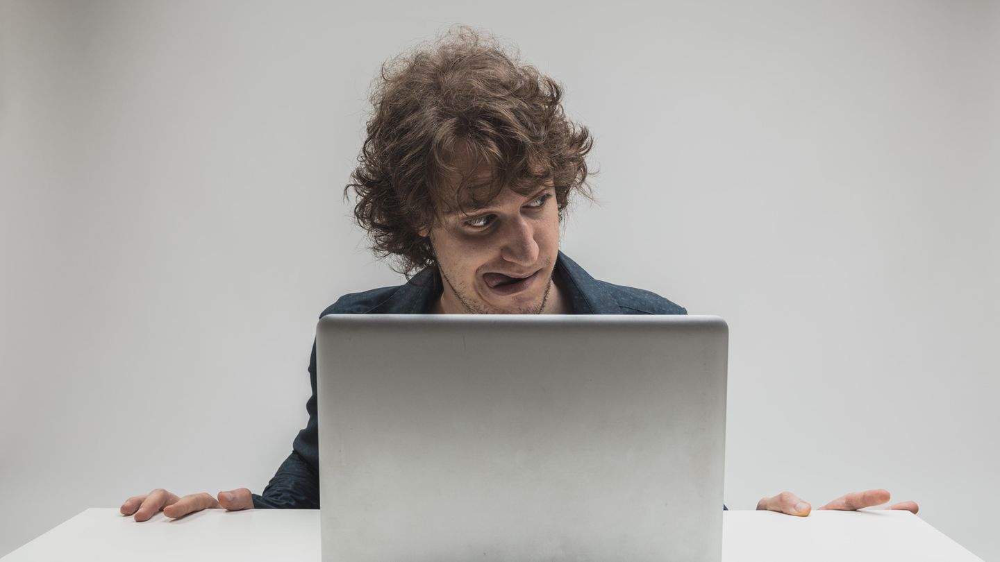 Ein Mann schaut gierigen Blickes Pornos auf seinem Computer