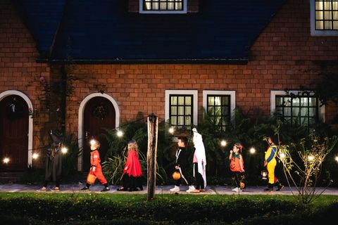 Verkleidete Kinder ziehen an Halloween durch die Straße