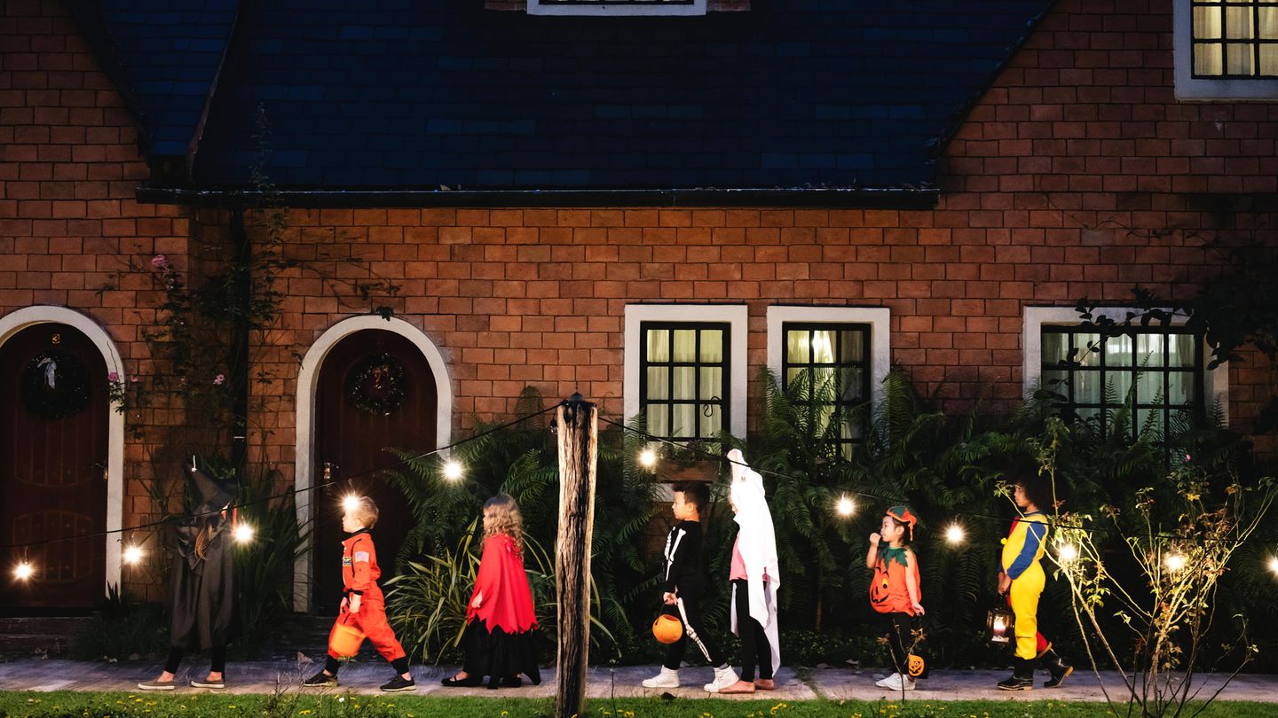 Verkleidete Kinder ziehen an Halloween durch die Straße