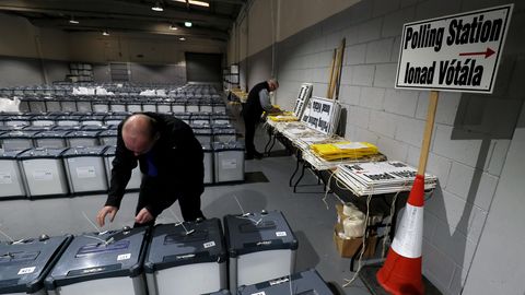 Ein Wahlhelfer bereitet in einer Halle die Wahlurnen vor
