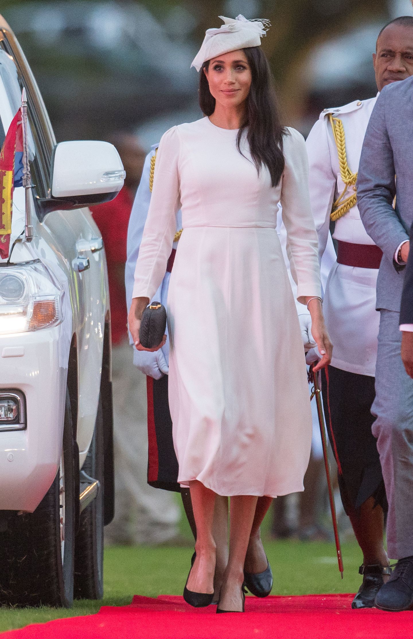 Herzogin Meghan bei ihrer Ankunft auf den Fidschi-Inseln. Ihr weißes Kleid stammt vom australischen Label Zimmermann, auch ihre Accessoires (Hut, Clutch, Schuhe) sind Designerstücke. Die Kosten für das komplette Outfit belaufen sich auf circa 3757 Euro.