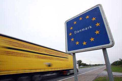 Ein LkW fährt an einem dänischen Grenzschild vorbei