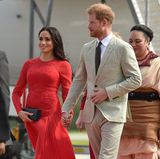 Ankunft auf Tonga im roten Faltenkleid von Self Portrait. Mit einem Preis von 427 Euro gehörte es zu Meghans günstigeren Outfits. Dabei unterlief der 37-Jährigen allerdings ein Fauxpas: Sie hatte vergessen das Etikett vom Saum zu entfernen.