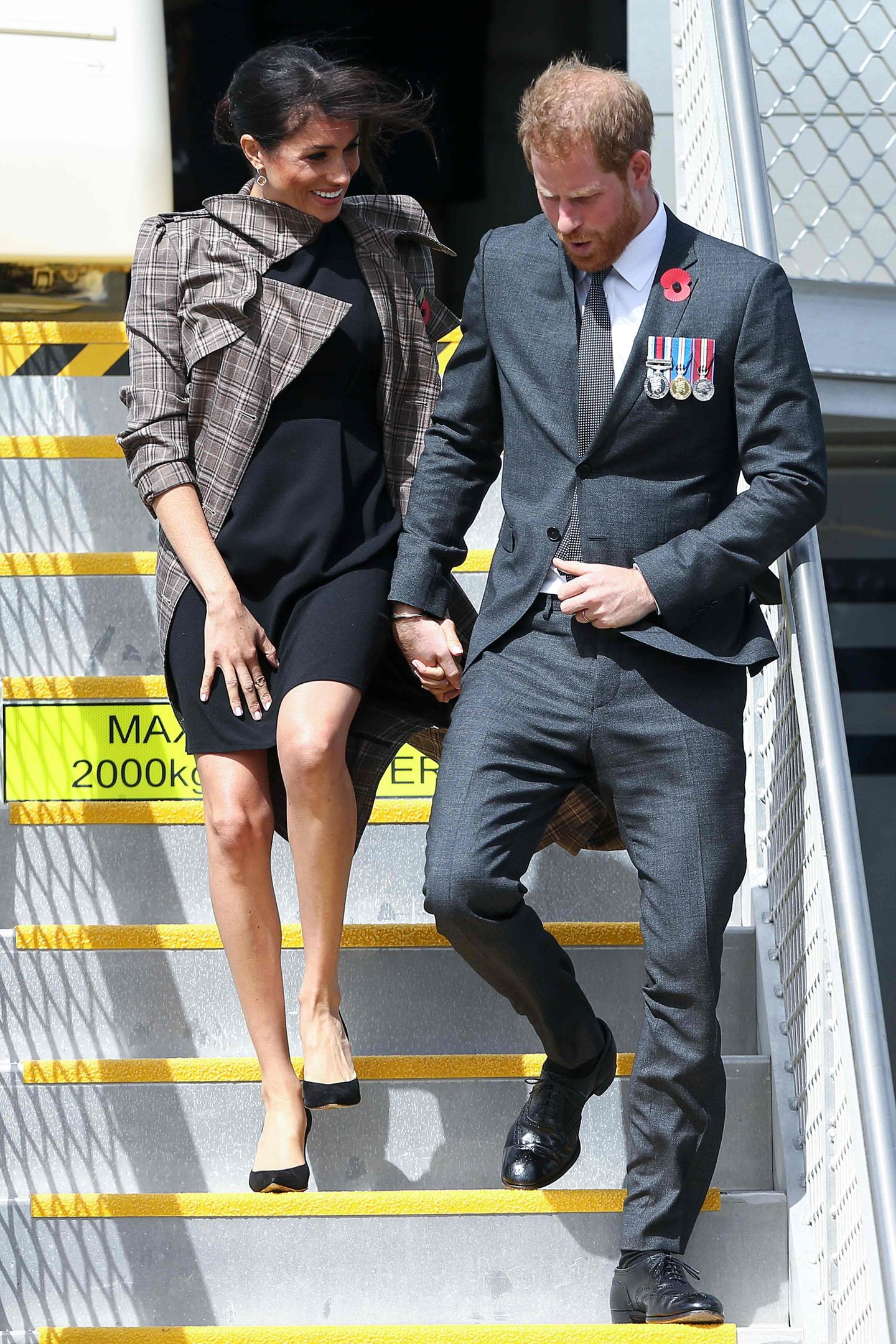 Stürmische Ankunft in Neuseeland. Auf dem Flughafen von Wellington trug Meghan einen Trenchcoat von Karen Walker (circa 600 Euro) und zum ersten Mal überhaupt ein Umstandskleid. Das war mit knapp 40 Euro besonders preisgünstig und stammt vom Onlinehändler Asos. 
