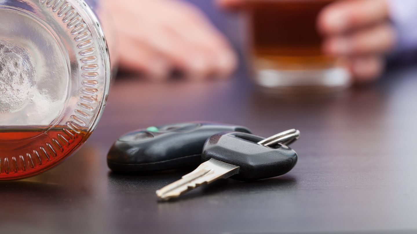 Autoschlüssel und daneben eine Flasche Schnaps