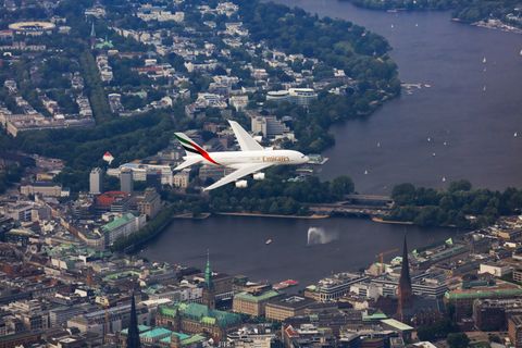 Ein Airbus A380 von Emirates fliegt über die Hamburger Innenstadt und die Alster