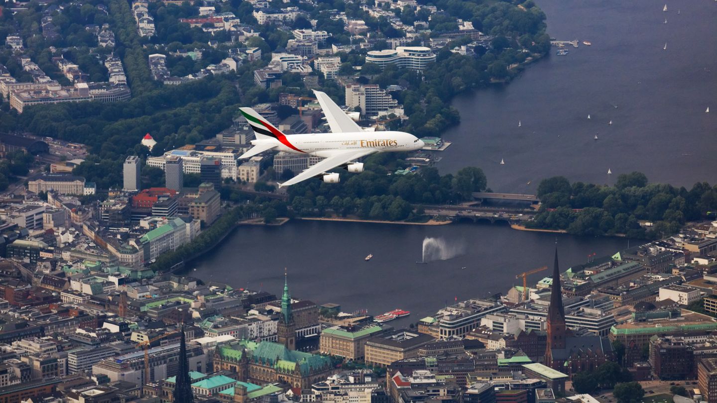 Ein Airbus A380 von Emirates fliegt über die Hamburger Innenstadt und die Alster