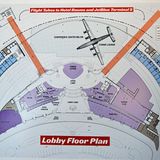 In der Lounge ist auch ein Plan vom Umbau des Saarinen-Terminals ausgestellt: Die Flächen des Konferenzzentrums sind in Violett und des Hotels mit 512 Zimmern Blau gehalten. Zwischen den beiden "Flight Tubes" (orange) soll ein Flugzeug parken, eine renovierte Super Constellation, die als Bar dienen wird.