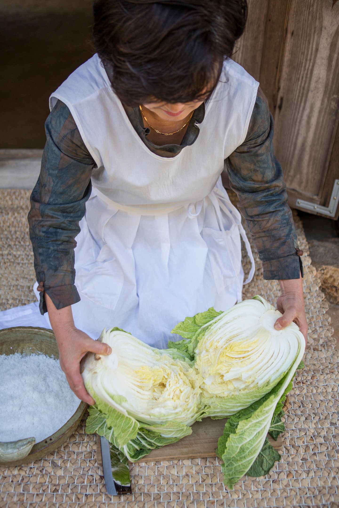 Originalrezept aus Korea: Kohl schneiden Am Anfang steht der Chinakohl. Frau Park schneidet ihn mit dem Messer am Strunk ein, um ihn dann händisch in zwei Hälften zu reißen. Der Klang, den der Kohlkopf dabei macht, ist quietschig und hohl, so als stäche und bräche man in eine Styroporbox – ein wichtiger Frischeindikator. Kohl schneiden Am Anfang steht der Chinakohl. Frau Park schneidet ihn mit dem Messer am Strunk ein, um ihn dann händisch in zwei Hälften zu reißen. Der Klang, den der Kohlkopf dabei macht, ist quietschig und hohl, so als stäche und bräche man in eine Styroporbox – ein wichtiger Frischeindikator.