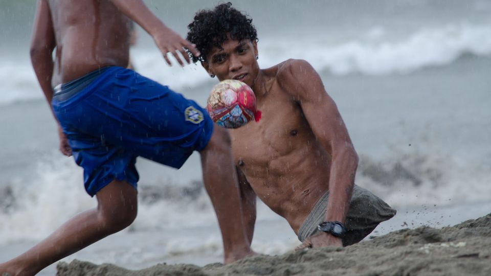 Alfonso Mendoza aus Venezuel spielt Fußball an einem Strand in Kolumbien