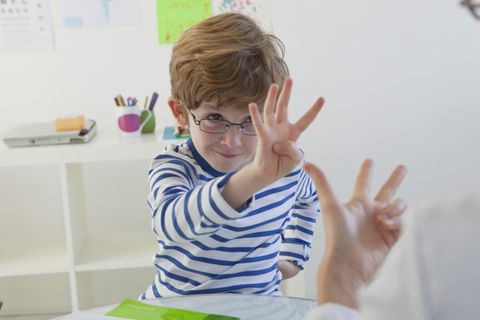 Ein kleiner Junge übt das Zählen mit den Fingern
