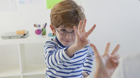 Ein kleiner Junge übt das Zählen mit den Fingern
