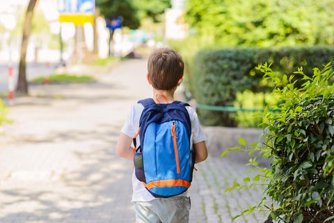 Ein Junge mit Schulranzen auf dem Rücken